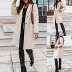 Woman wearing a beige coat and black knee-high boots in an urban setting.